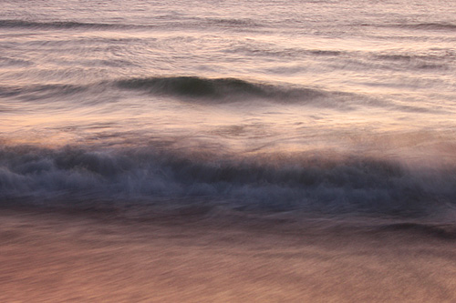 Robin made this image with a slow shutter speed during the soft pastel light before dawn. Slow shutter speeds render moving waves with a painterly effect.